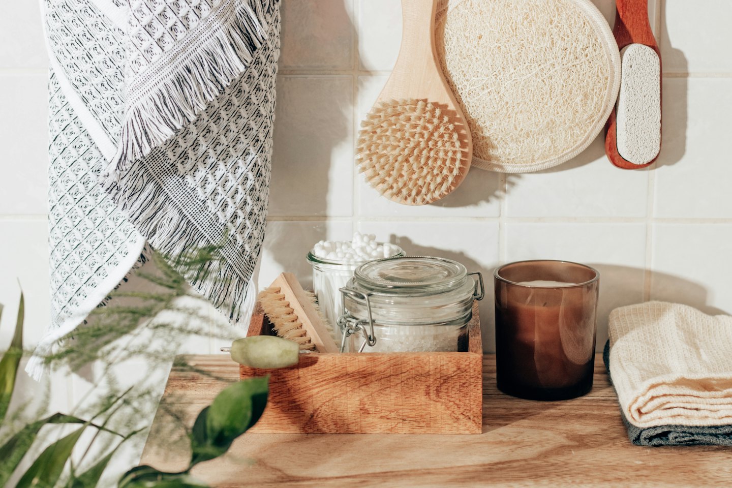 Natural self-care items on a wooden tray with towels.